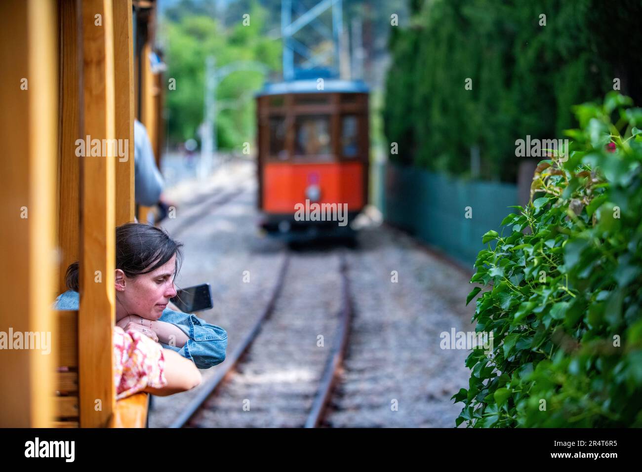 Turisti all'interno del tram d'epoca al porto di Soller centro villaggio. Il tram opera un servizio 5kms dalla stazione ferroviaria nel villaggio di Soller Foto Stock