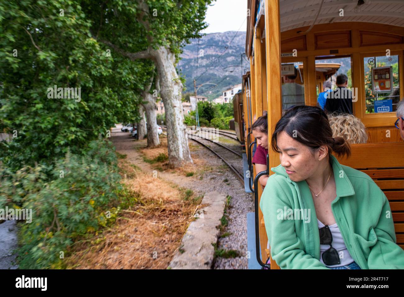Turista asiatico all'interno del tram d'epoca al porto di Soller centro villaggio. Il tram opera un servizio 5kms dalla stazione ferroviaria di Soller vi Foto Stock