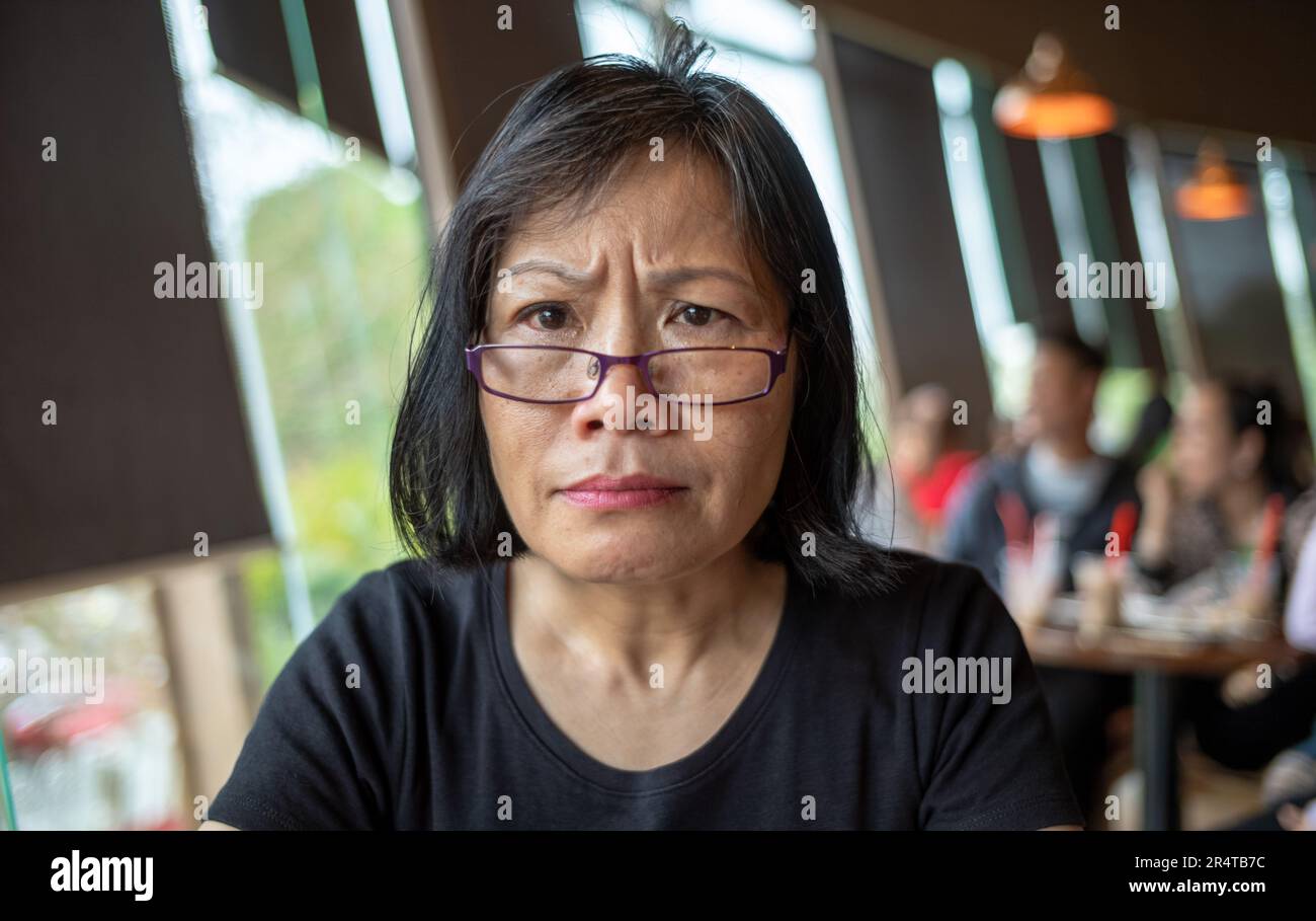Una donna vietnamita sembra perplessa mentre guarda alla macchina fotografica in un bar a Danang, Vietnam Foto Stock