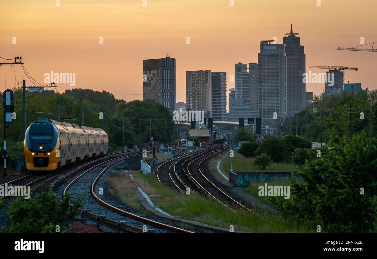 Skyline di Amsterdam al tramonto, edifici di uffici moderni visti dalla ferrovia al tramonto Foto Stock
