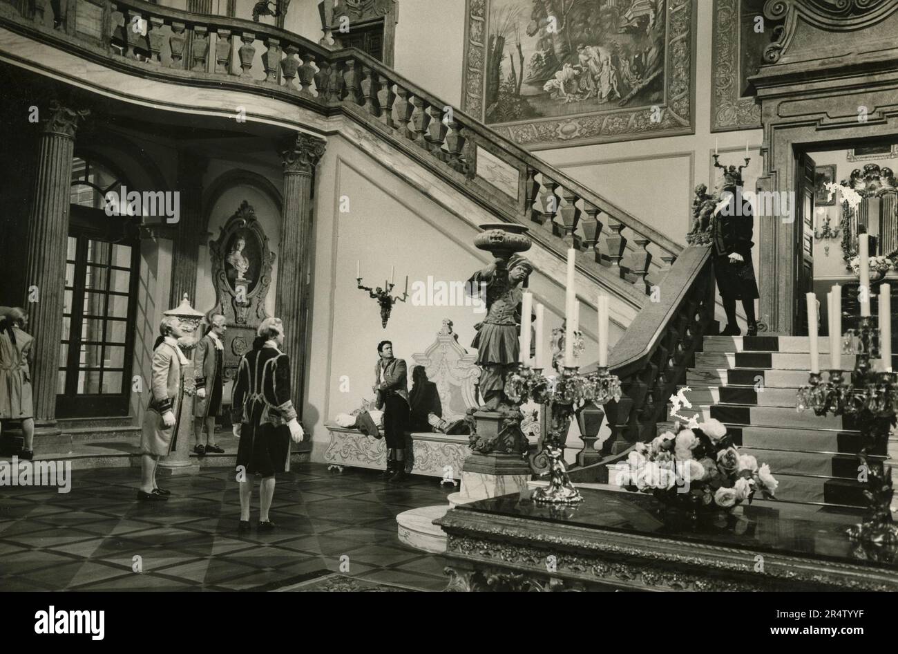 Scena da film non identificato con scalinata in marmo e attori in costume, 1960s Foto Stock