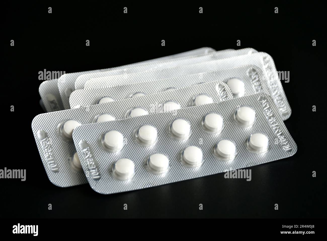 Compresse bianche compresse compresse compresse non rivestite in blister isolate su sfondo nero. Foto Stock