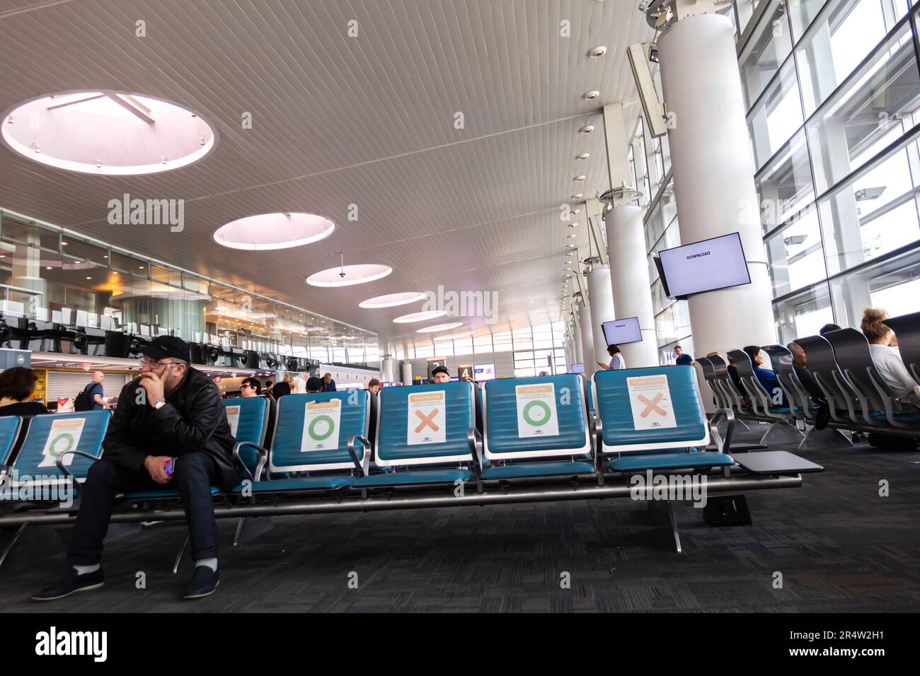 Passeggeri seduti nella sala d'attesa del terminal dell'aeroporto internazionale Zvartnots di Erevan, Armenia. Foto Stock