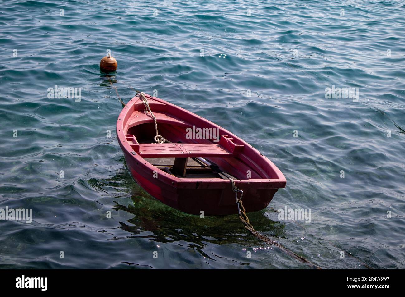 Una piccola barca rossa solitaria Foto Stock