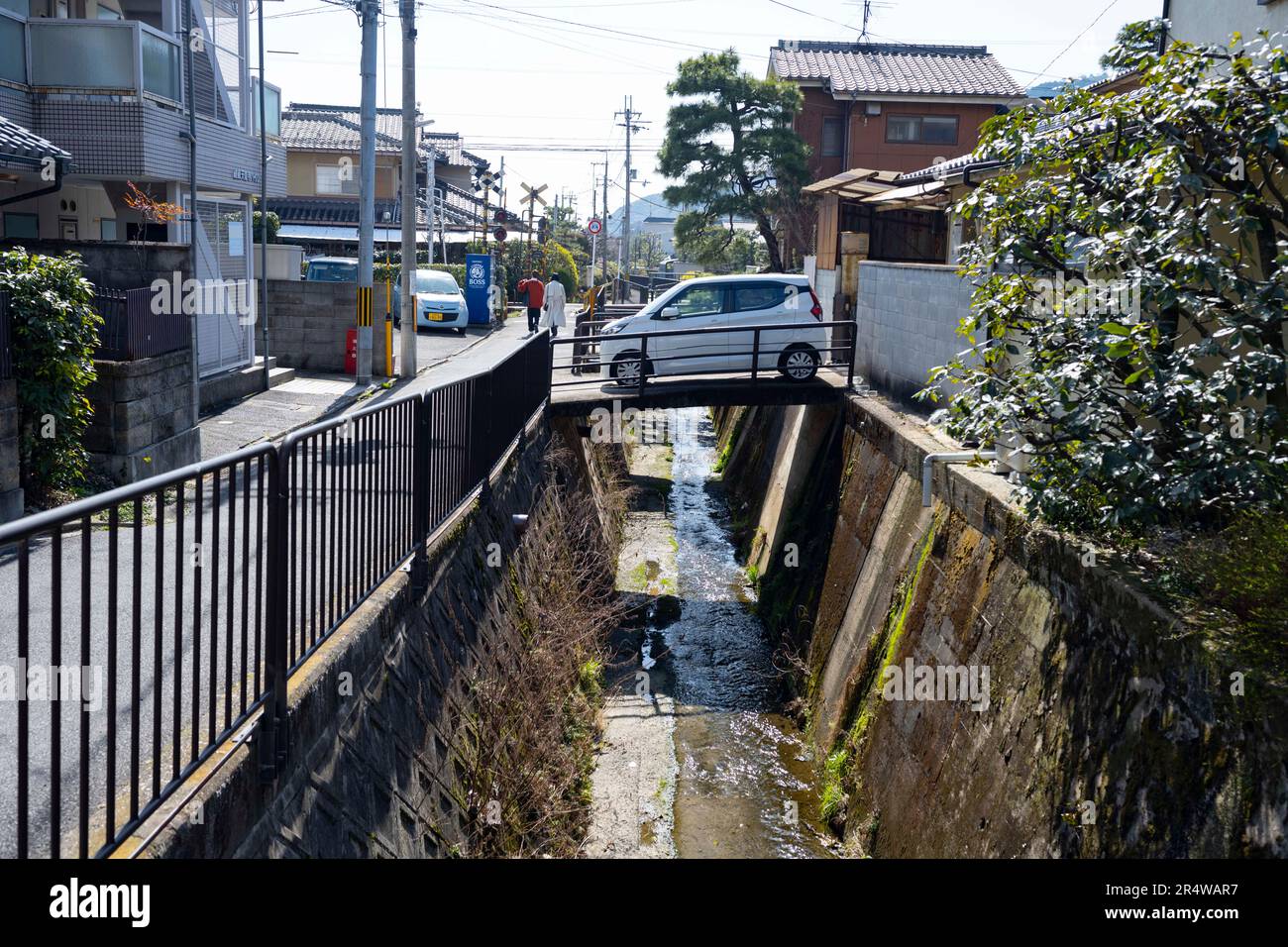 Kyoto, Giappone. 7th Mar, 2023. Una piccola auto che attraversa un ponte su un canale. Kyoto (äº¬éƒ½) è una città storica importante del Giappone, ricca di patrimonio culturale e fascino tradizionale. Conosciuta per i suoi templi iconici, i pittoreschi giardini e i monumenti storici come Kinkaku-ji e Fushimi Inari Taisha, Kyoto offre uno scorcio del passato giapponese. I suoi festival vibranti, la cucina squisita e l'atmosfera serena affascinano i visitatori da tutto il mondo. È un vivace centro per l'industria turistica giapponese e ospita molte aziende come Nintendo. Il Giappone ha una popolazione in calo e una popolazione che invecchia a causa di un Foto Stock