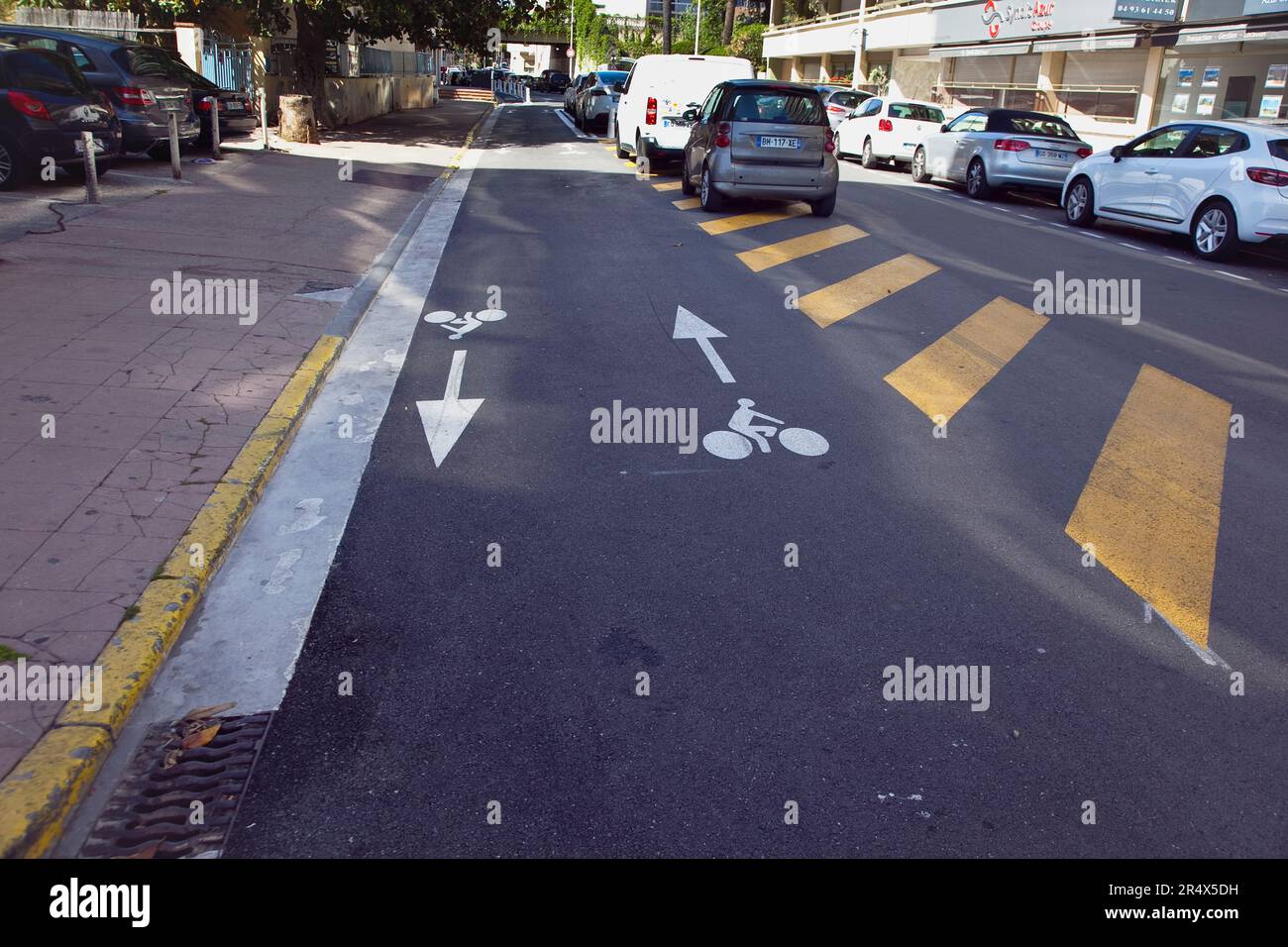 Francia, Provenza-Alpi-Costa Azzurra, Antibes Juan-les-Pins, pista ciclabile con cartelli dipinti sulla strada. Foto Stock