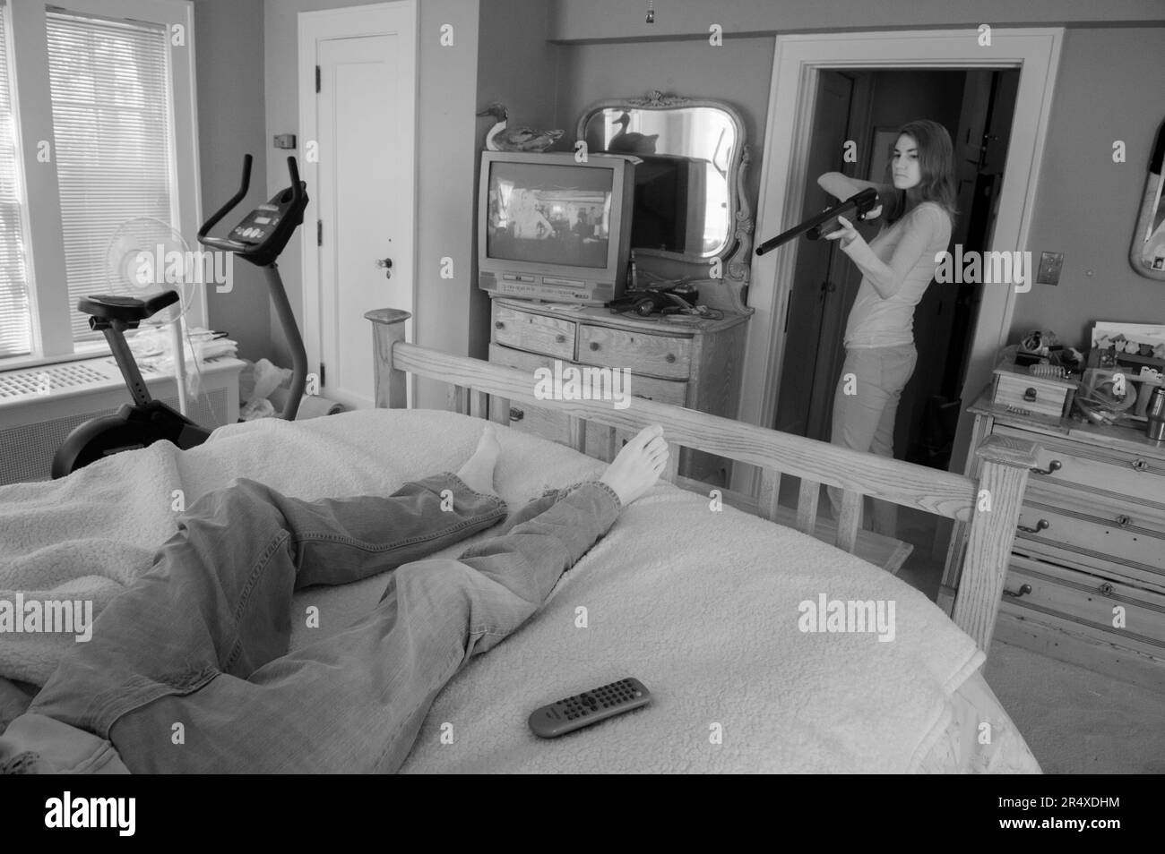 Giovane donna si prepara a sparare a un uomo a letto; Lincoln, Nebraska, Stati Uniti d'America Foto Stock