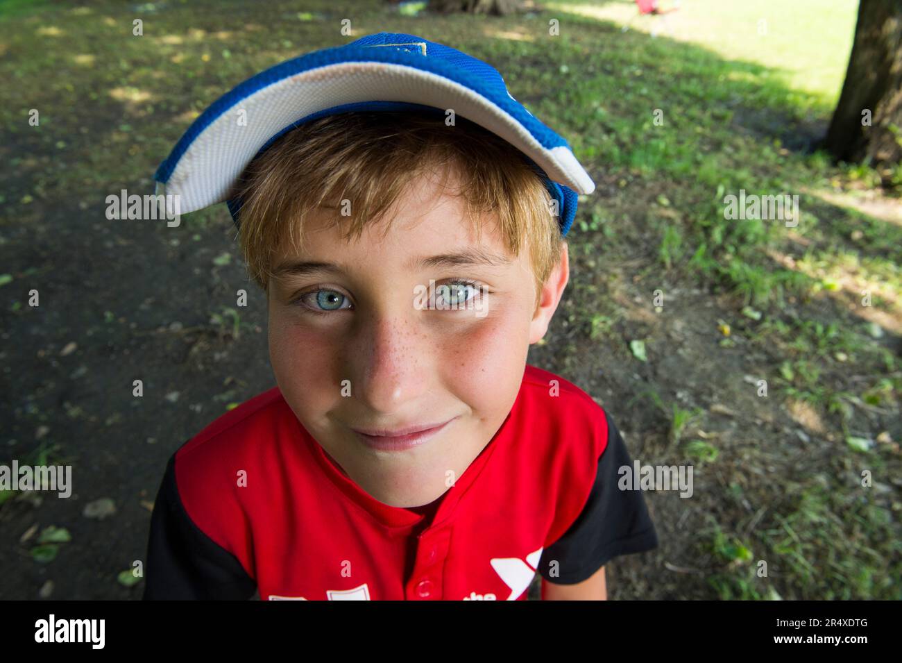 Il ragazzo elementare sorride per la telecamera prima del suo gioco di t-ball; Lincoln, Nebraska, Stati Uniti d'America Foto Stock