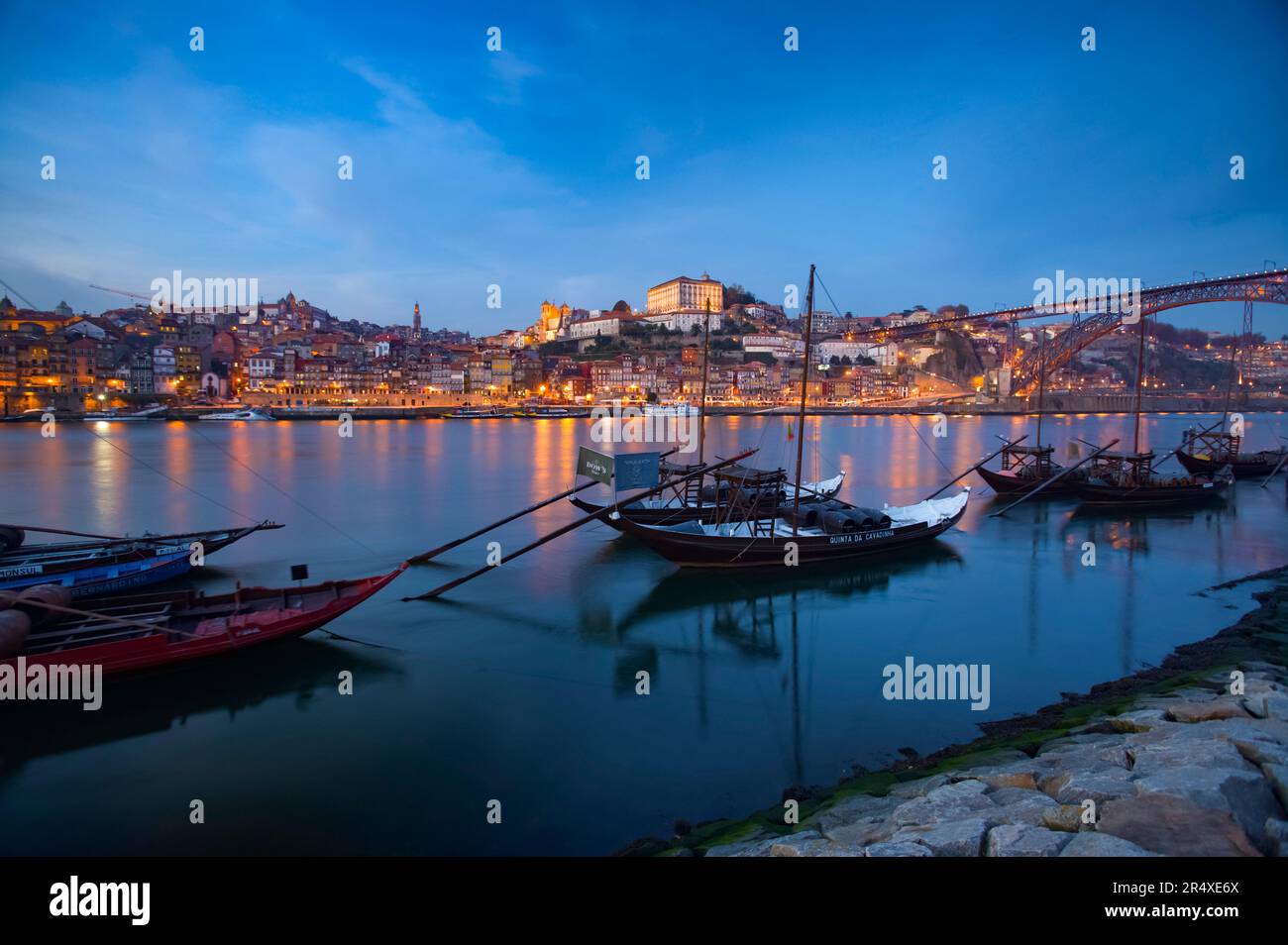 Barche che trasportano botti di vino nel porto di Oporto al crepuscolo; Porto, Portogallo Foto Stock