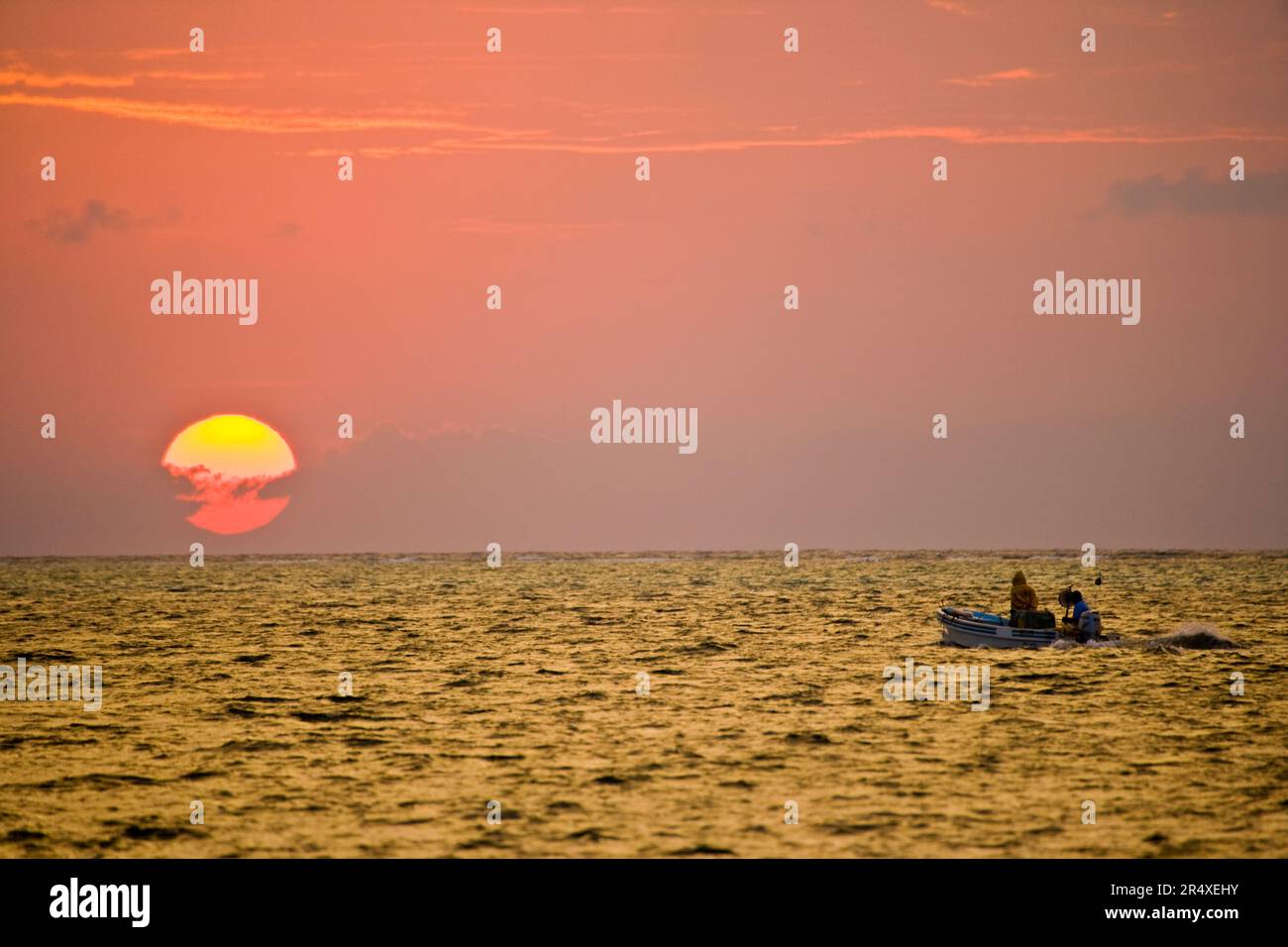 Barca da pesca al tramonto; Turneffe Island, Belize Foto Stock