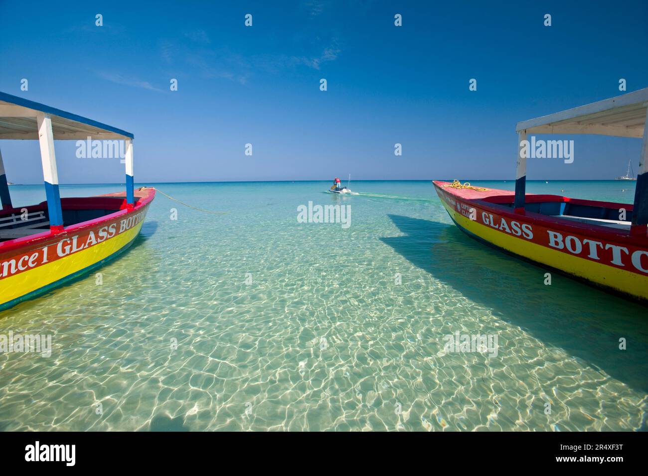 Barche turistiche con fondo in vetro e motoscafo lungo la spiaggia di Negril; Negril Beach, Giamaica, Indie occidentali Foto Stock