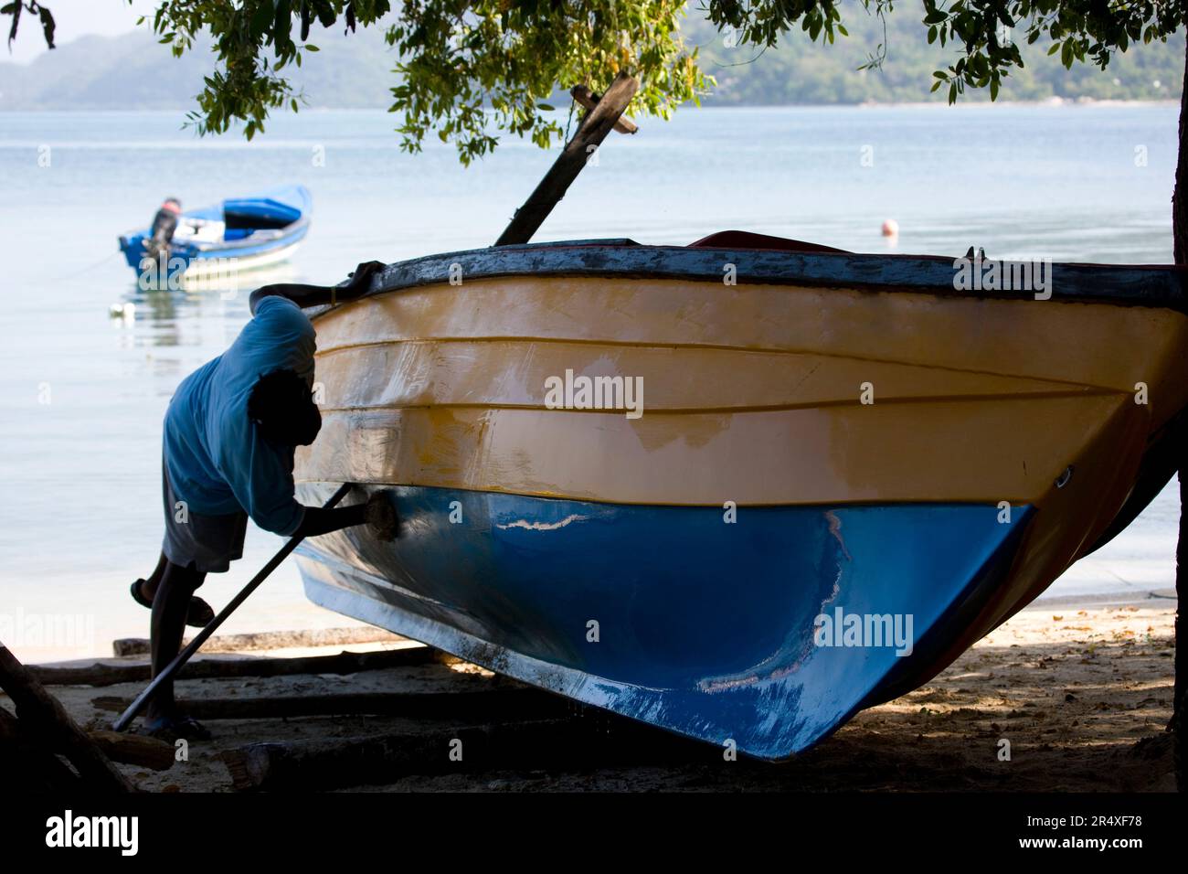 Il pescatore di Bluefields Bay pulisce la sua barca in Giamaica; Bluefields Bay, Giamaica Foto Stock