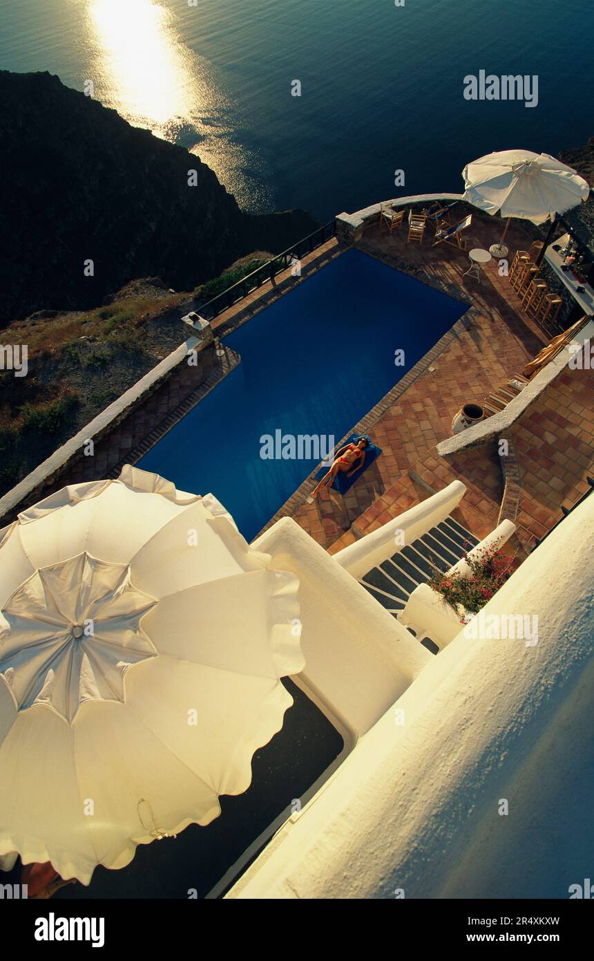 Vista rialzata di una donna che si rilassa in piscina; Santorini, Grecia Foto Stock