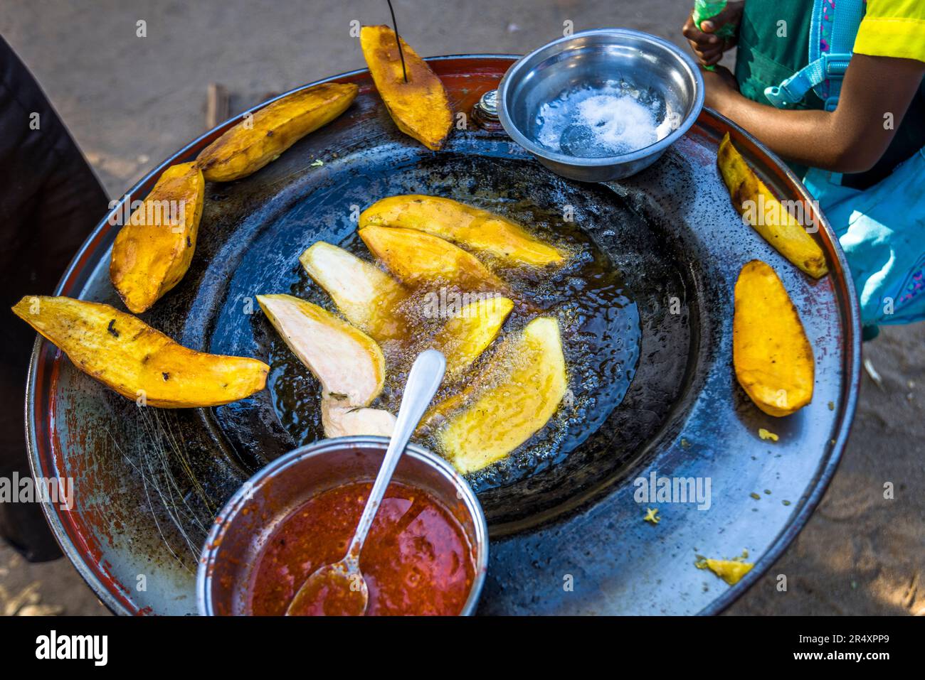 Gli studenti acquistano patate dolci fritte prima della scuola a Nkopola, Malawi Foto Stock