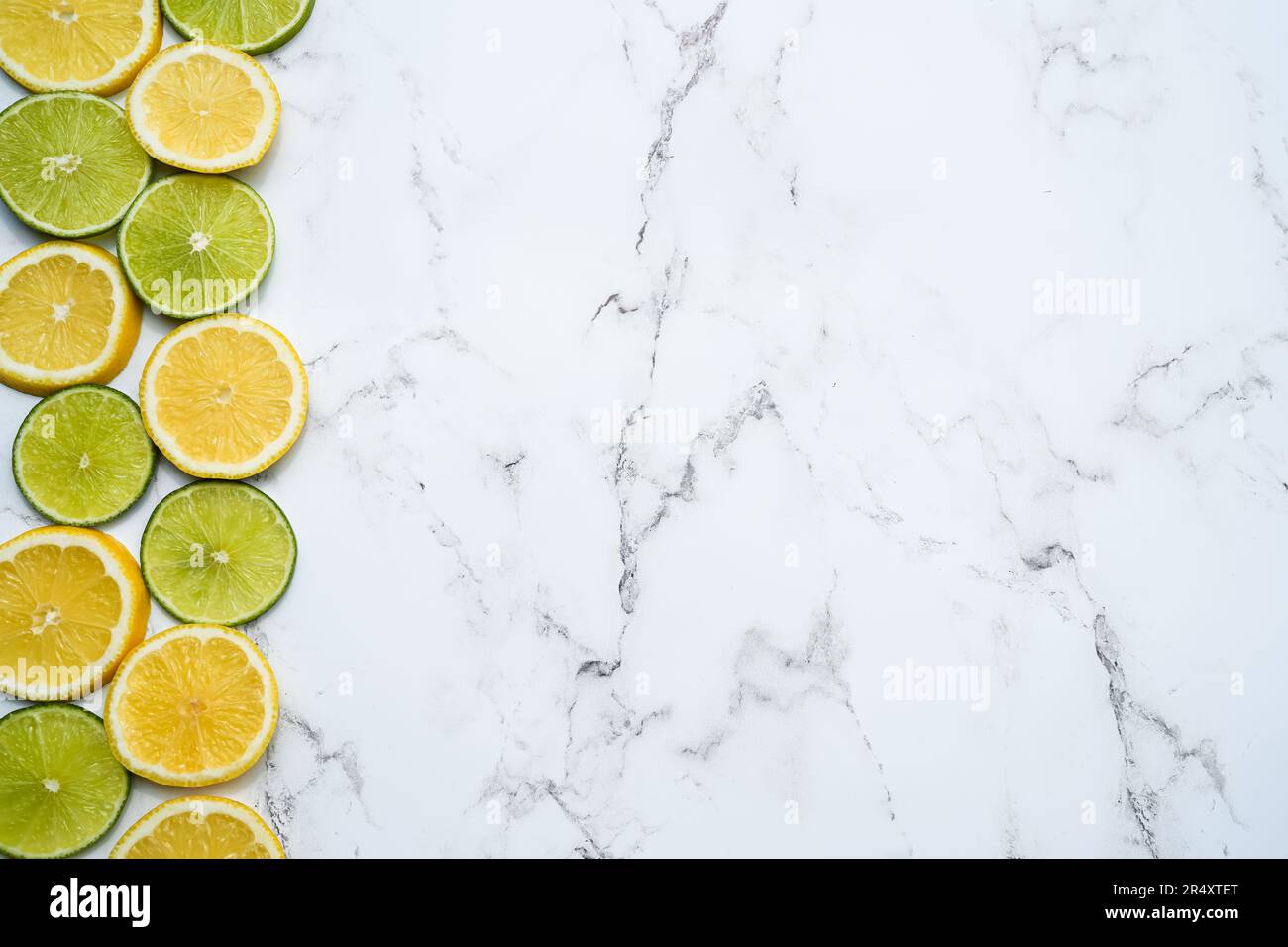 Fondo di agrumi, limone e lime su sfondo marmoreo, spazio copia, sfondo cornice estiva, fresco e succoso, composizione di frutta, tabella Foto Stock