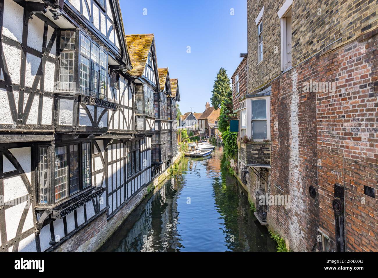 Canale d'acqua del fiume Stour da Canterbury, con barca turistica che naviga sul fiume. Edifici tipici che si affacciano sul fiume Stour a Canterbury, Kent, Foto Stock