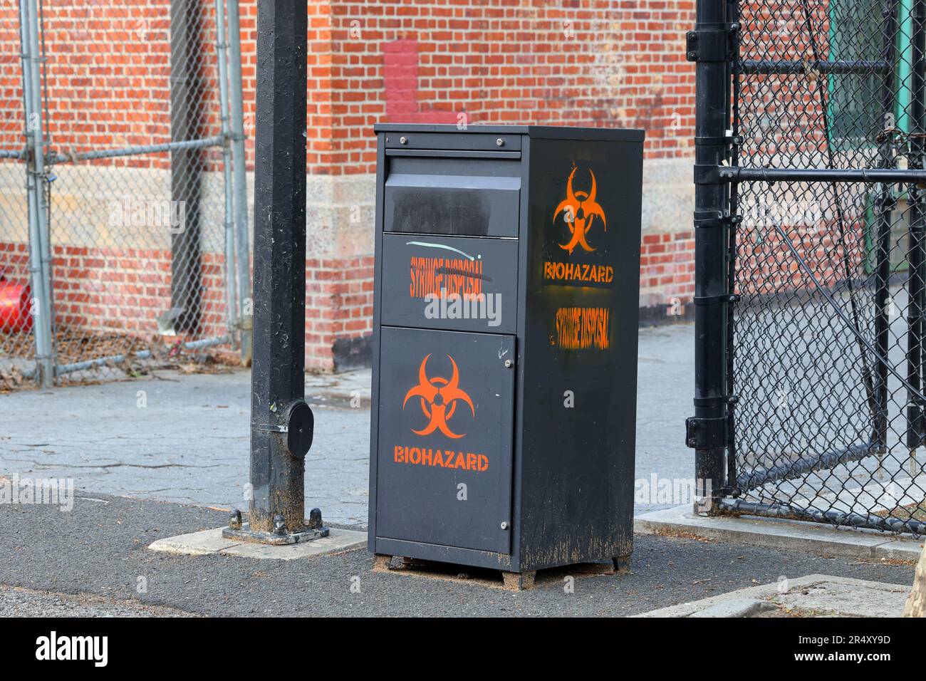 Un contenitore per lo smaltimento di oggetti taglienti e siringhe per la raccolta di aghi ipodermici in un parco di New York dove non sono disponibili altri mezzi per lo smaltimento sicuro. Foto Stock