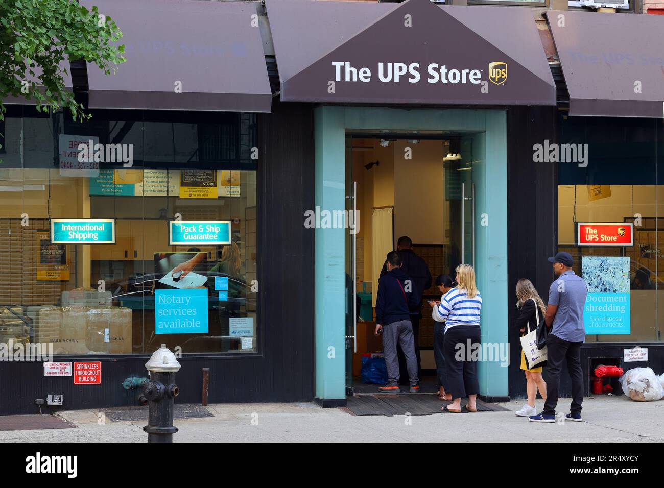 Persone in coda fuori da un UPS Store al 217 Centre St a Manhattan SoHo, New York. Foto Stock
