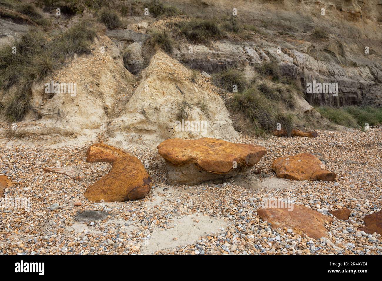 Primo piano di noduli di pietra di ferro rossa (sideritica) sulla spiaggia vicino alla scogliera a Hengistbury Head, Dorset, Inghilterra, Regno Unito Foto Stock