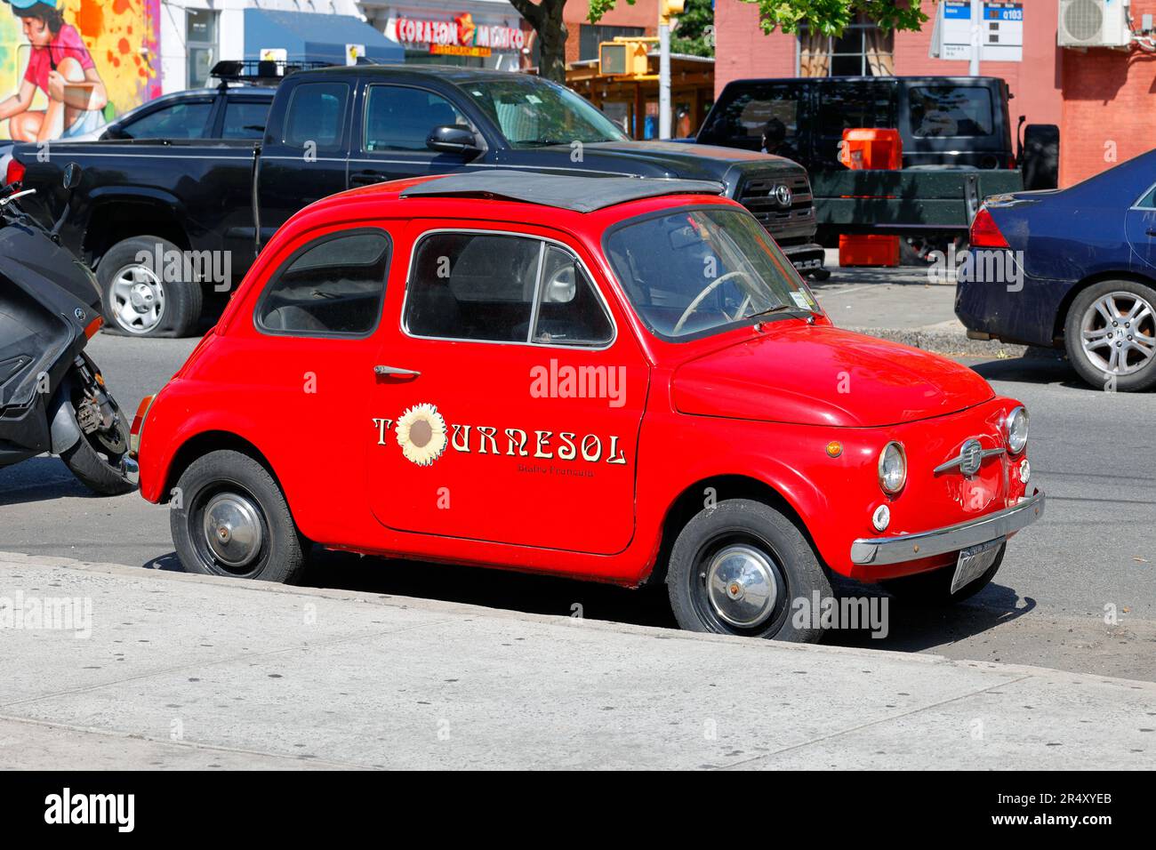 Un'auto d'epoca rossa Fiat 500 con Tournesol Bistro Francais segnata sulle porte. Foto Stock