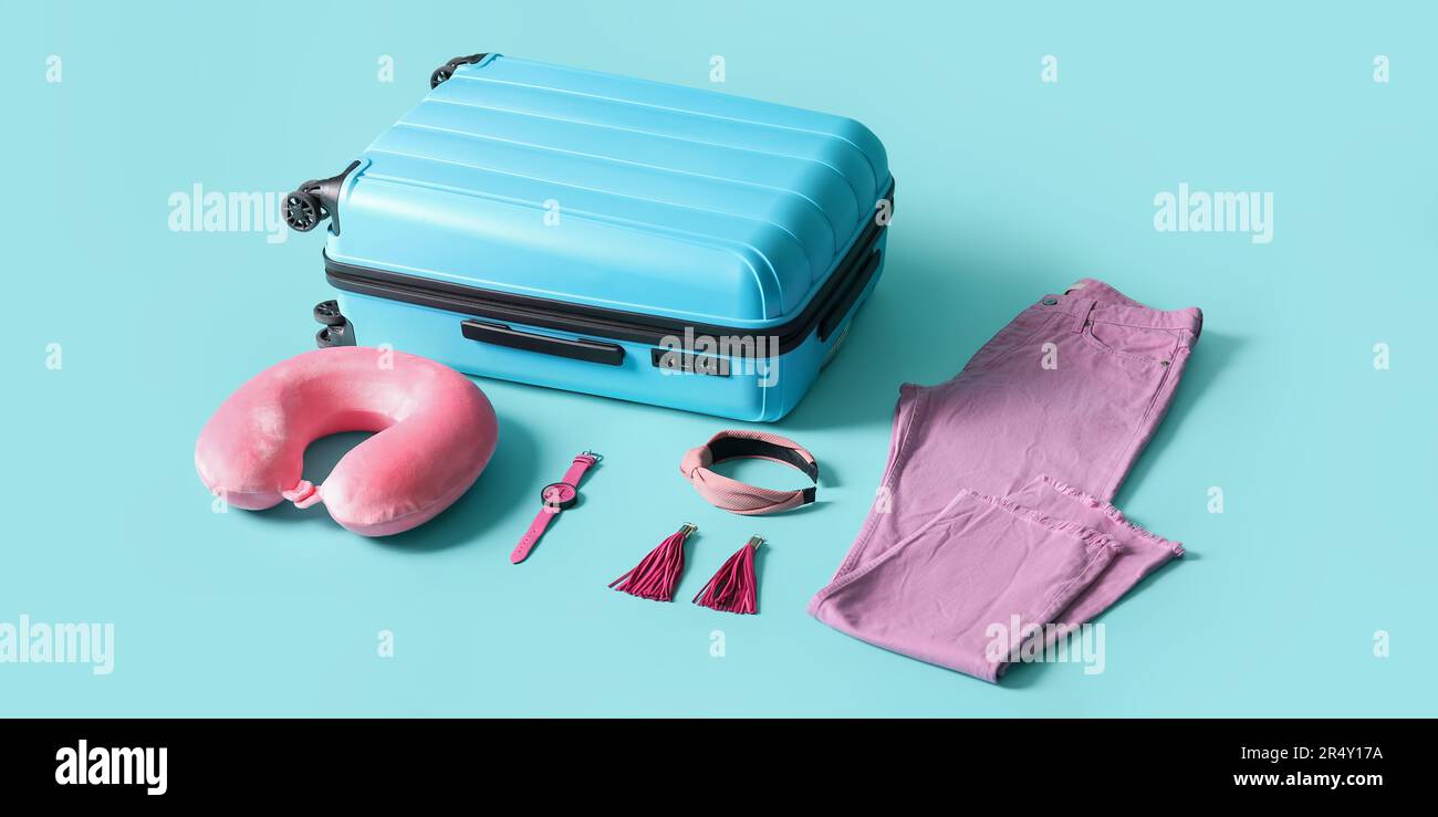 Valigia con accessori da viaggio su sfondo azzurro Foto stock - Alamy
