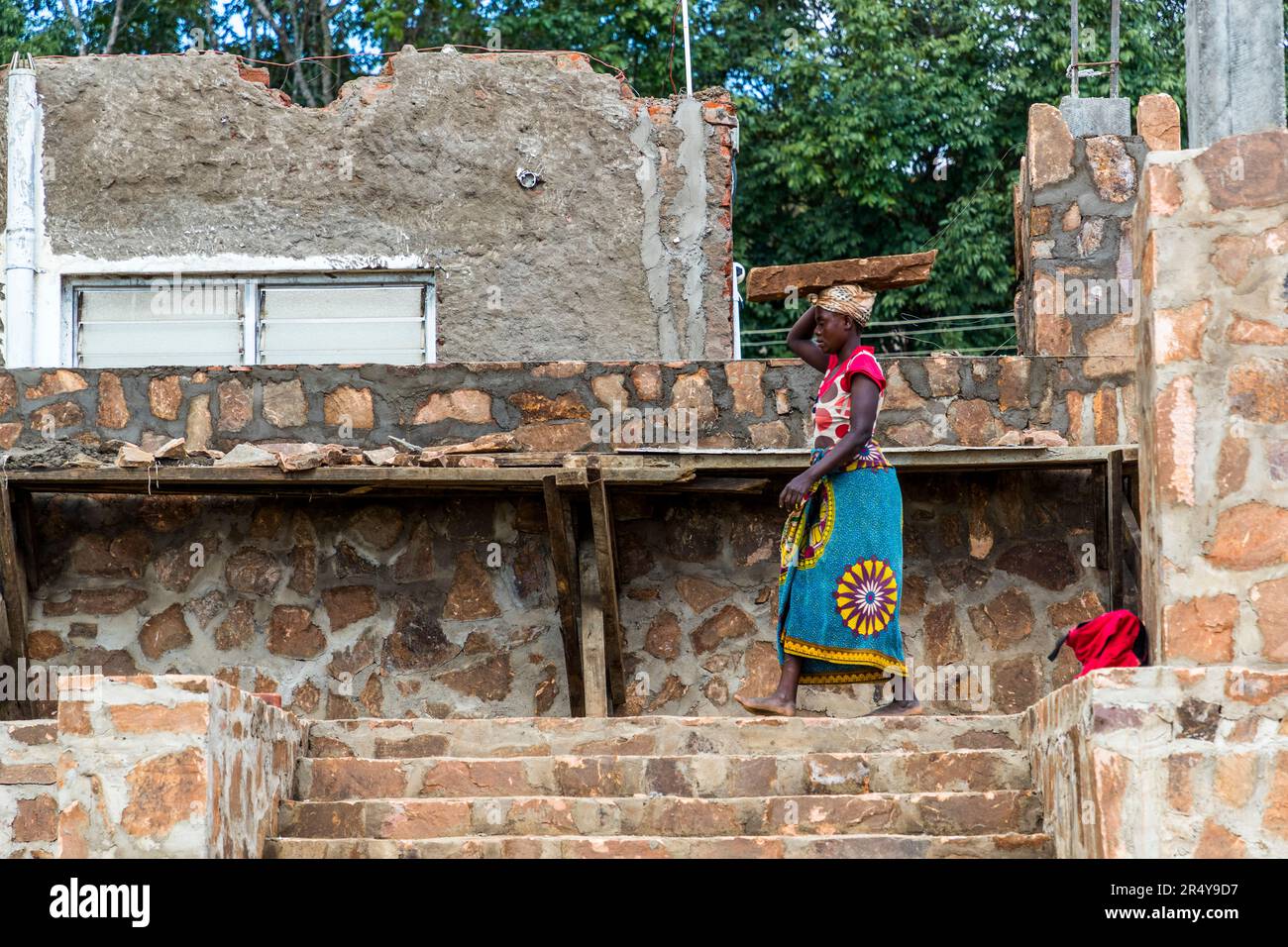 Lavori di costruzione di una casa in pietra vicino a Lilongwe. Uomini e donne lavorano insieme nel cantiere di Kumbali Country Lodge a Lilongwe, Malawi Foto Stock
