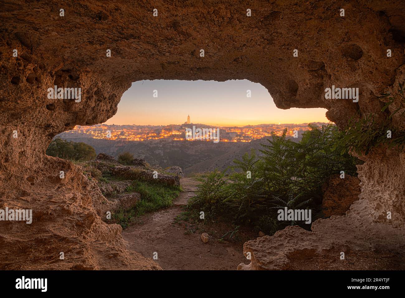 Matera, Italia come si vede dall'interno di un'antica grotta al crepuscolo. Foto Stock