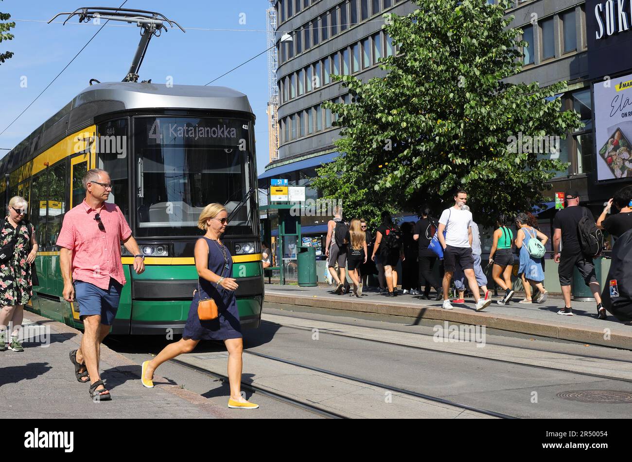 Helsinki, 20 agosto 2022: Tram e persone alla fermata del tram sulla via Mannerheimintie fuori dai grandi magazzini Sokos. Foto Stock