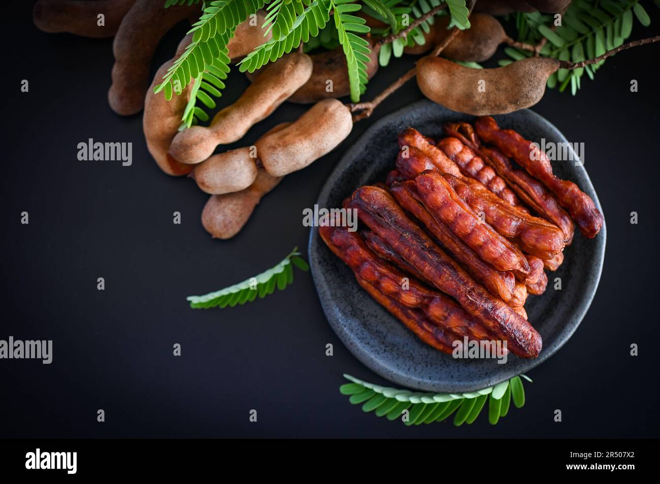 Tamarind buccia in piatto frutta tropicale estate, Tamarind dolce per cibo frutta matura tamarinds su piatto e sfondo bianco - vista dall'alto Foto Stock