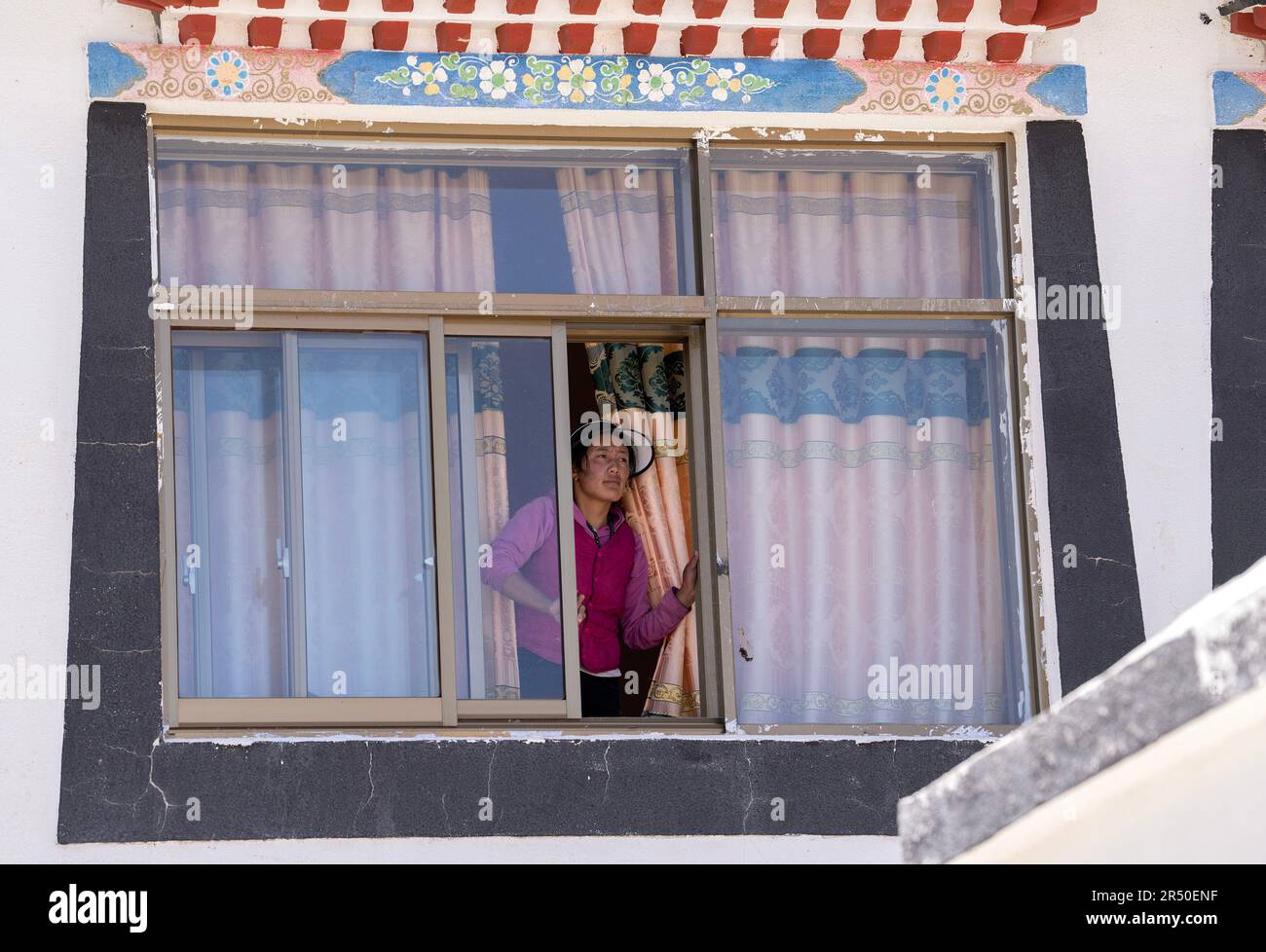(230531) -- NGARI, 31 maggio 2023 (Xinhua) -- Una grande figlia-in legge-di Losang Zhamdu, guarda fuori dalla finestra della sua 'quinta generazione' casa in Demqog Village, Zhaxigang Township, Gar County nella prefettura di Ngari della regione autonoma del Tibet del sudovest della Cina, 28 maggio 2023. Seduto al sole fuori della sua residenza nel villaggio di Demqog, Zhaxigang Township, Gar County nella prefettura di Ngari del Tibet, Losang Zhamdu di 84 anni raccontò una storia delle cinque case in cui aveva vissuto.'mia madre ed io vivevamo insieme in una tenda fatta di capelli di yak, Tutti i nostri possedimenti erano una giacca di pelliccia di capra e un blanke tibetano logoro Foto Stock