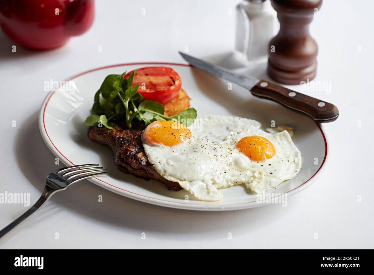 Filetto di bistecca con uova fritte, hashbrown e pomodoro alla griglia Foto Stock