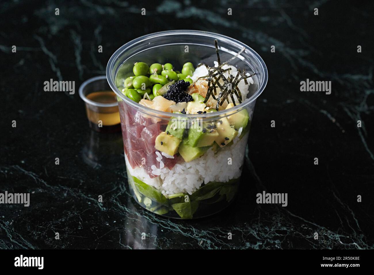 Una sana ciotola con tonno, avocado e edamame da portare via Foto Stock