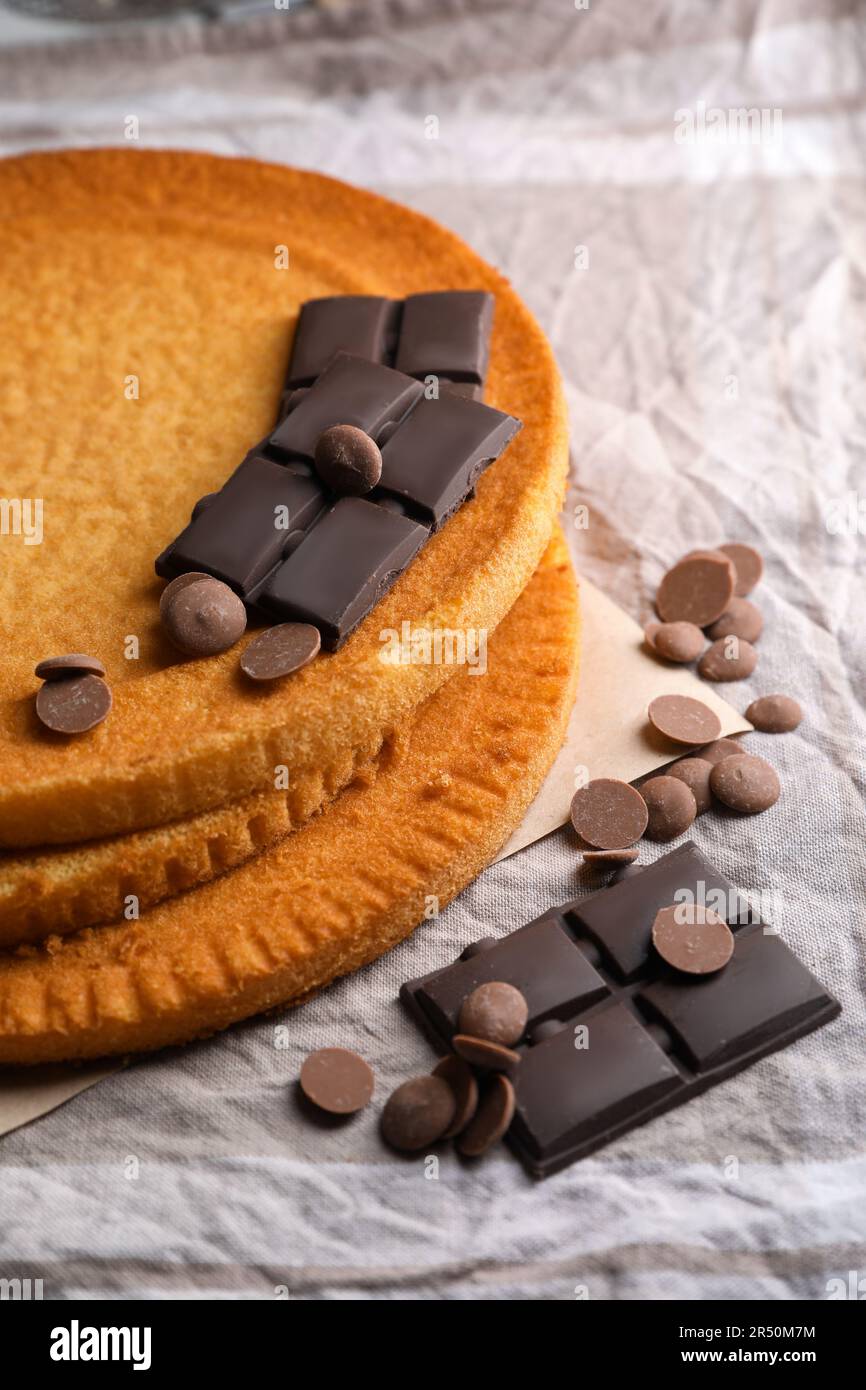 Deliziose torte fatte in casa e diversi tipi di cioccolato su tovaglia grigia, primo piano Foto Stock