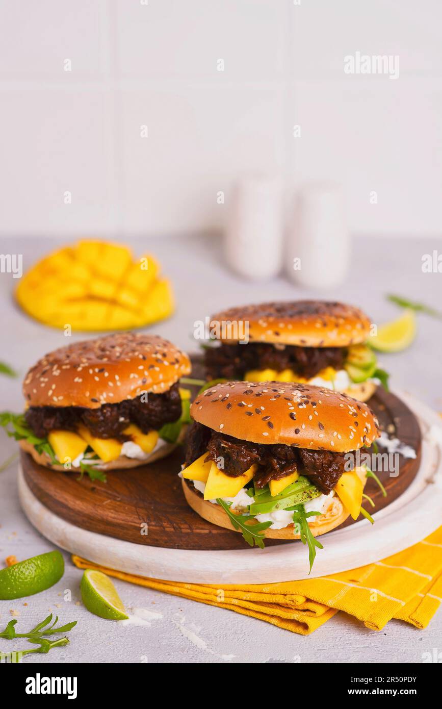 Hamburger con manzo in salsa scura, rucola, mango, avokado e salsa di yogurt all'aglio Foto Stock