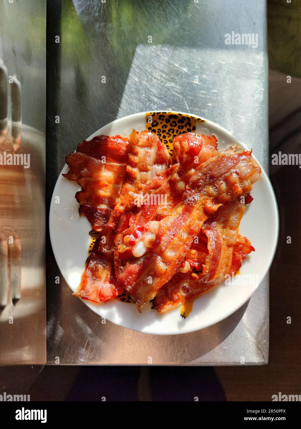 Fette di pancetta fritte sul piatto Foto Stock