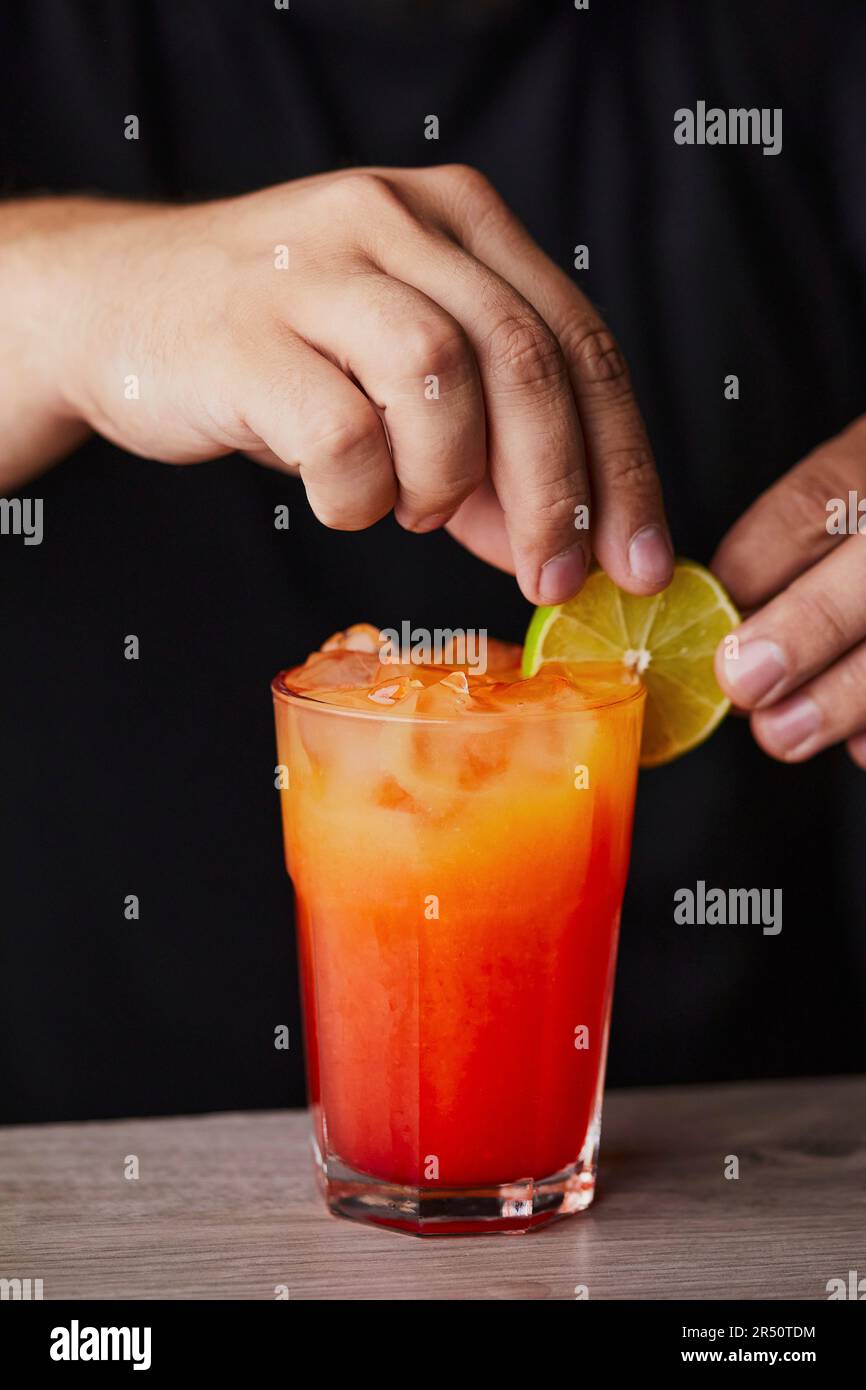 Mescolare mai Tai - guarnire la bevanda con la fetta di lime Foto Stock