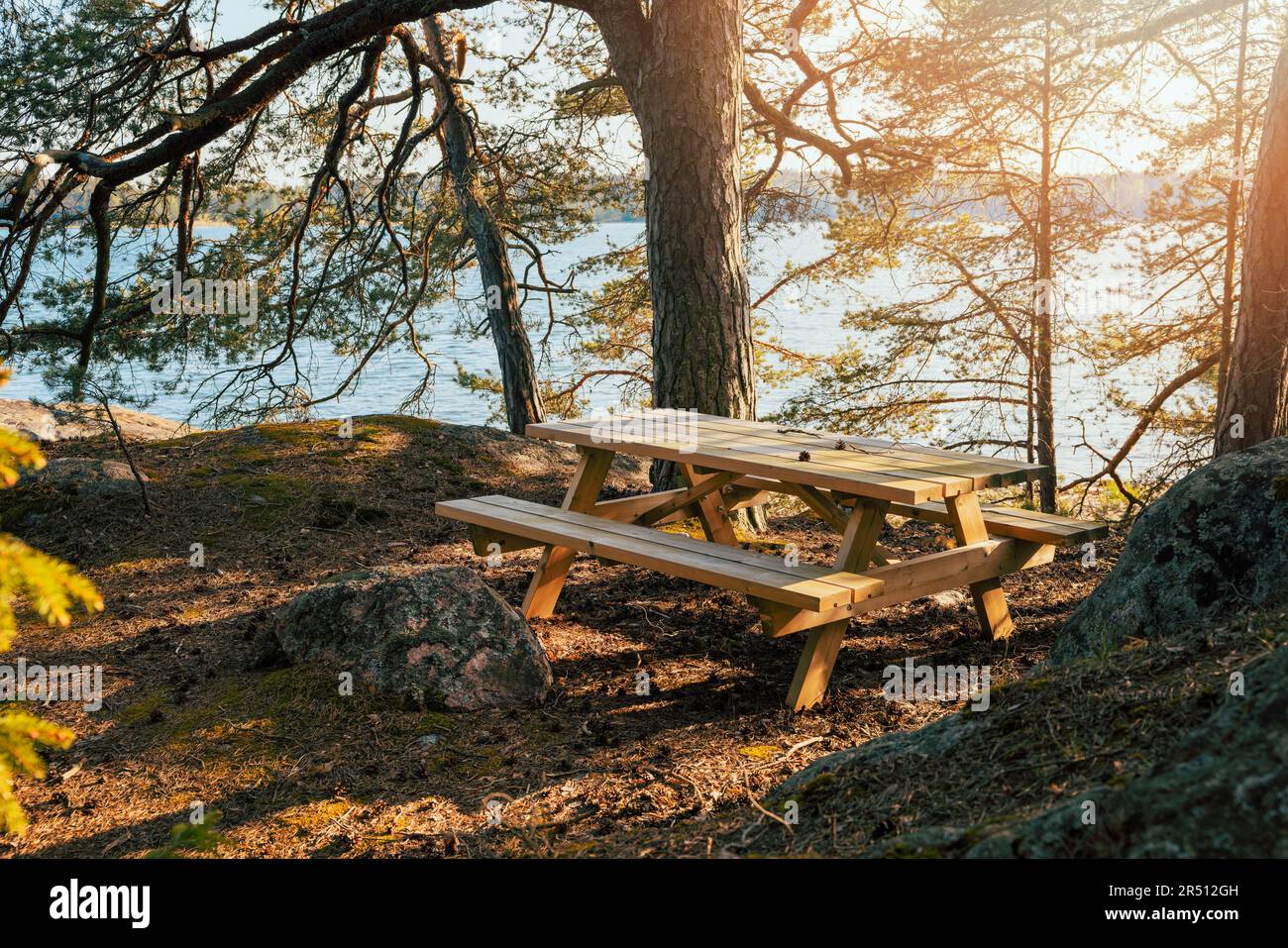 tavolo da picnic in legno presso il campeggio nella foresta vicino al lago Foto Stock