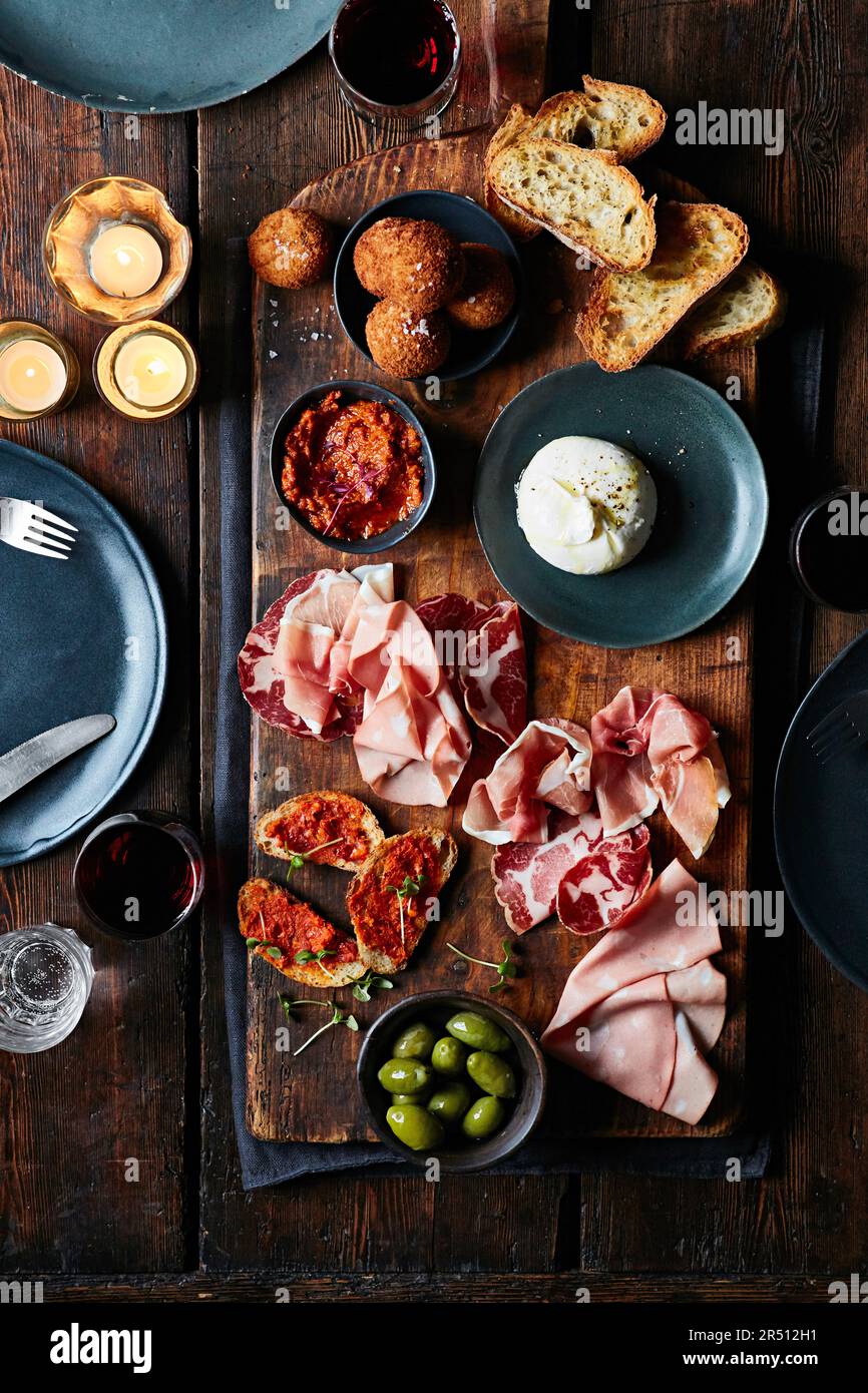 Piatto di salumi con burrata, olive e mini arancini Foto Stock