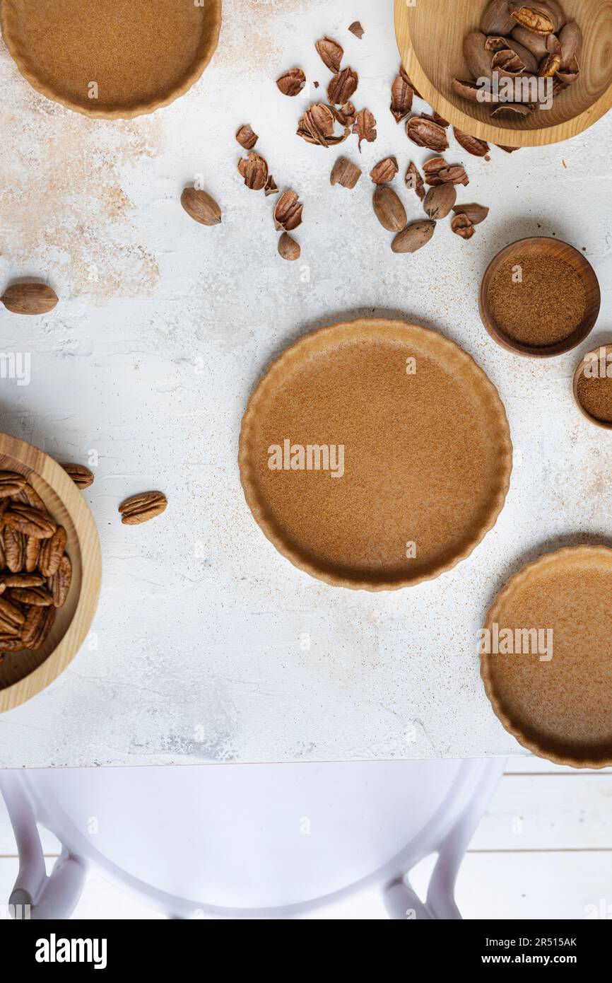 Croste di torta al forno su un tavolo con noci pecan Foto Stock