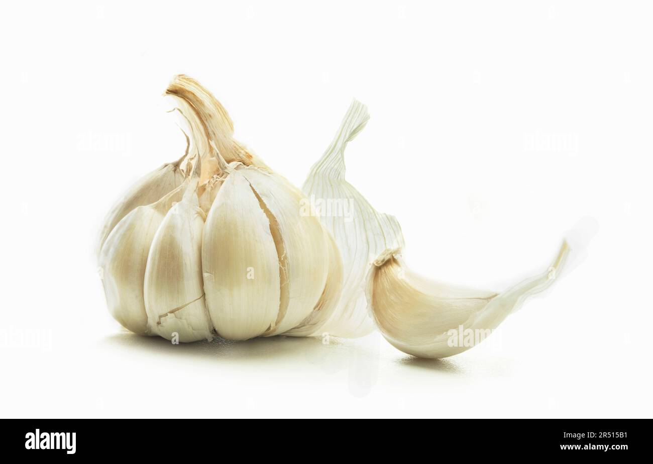 Bulbo d'aglio e uno spicchio d'aglio su fondo bianco Foto Stock