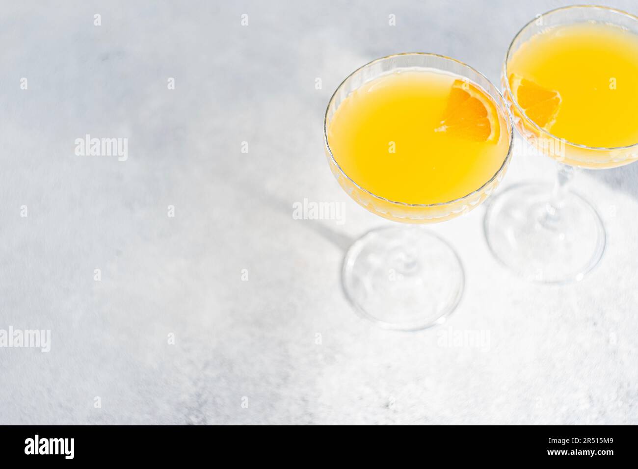 Bicchiere di cocktail mimosa su sfondo di pietra nelle giornate di sole Foto Stock