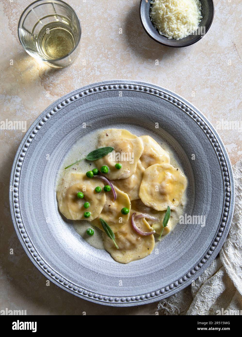 Ravioli di zucca alle butternut in salsa di salvia con piselli verdi Foto Stock