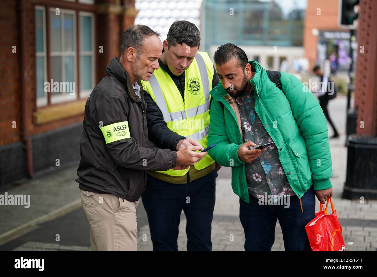 I membri del sindacato dei conducenti Aslef aiutano un passeggero con opzioni di viaggio alternative sulla linea picket alla stazione di Moor Street a Birmingham. Nei prossimi giorni i passeggeri delle ferrovie subiranno nuove perturbazioni nei viaggi a causa di ulteriori scioperi nelle dispute a lungo termine sulle retribuzioni, i posti di lavoro e le condizioni. Data immagine: Mercoledì 31 maggio 2023. Foto Stock