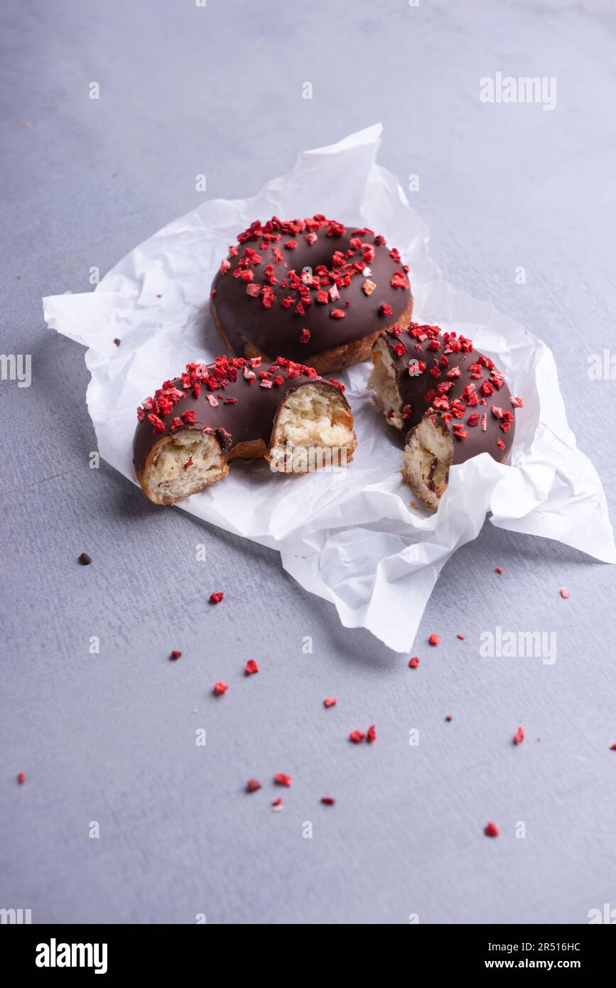 Ciambelle al cioccolato fondente con fragole liofilizzate Foto Stock
