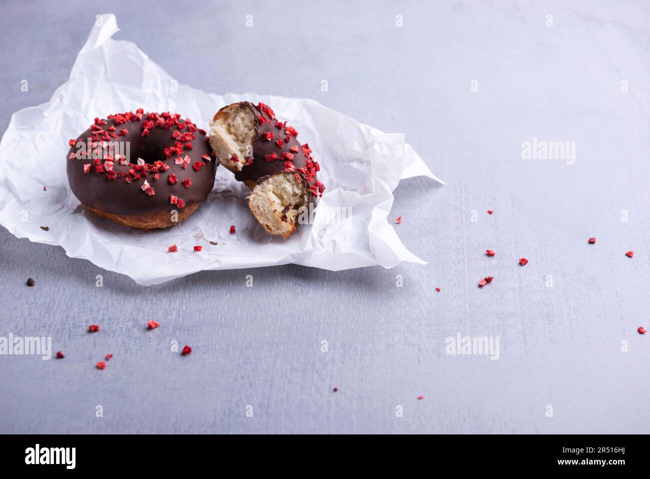 Ciambelle al cioccolato fondente con fragole liofilizzate Foto Stock