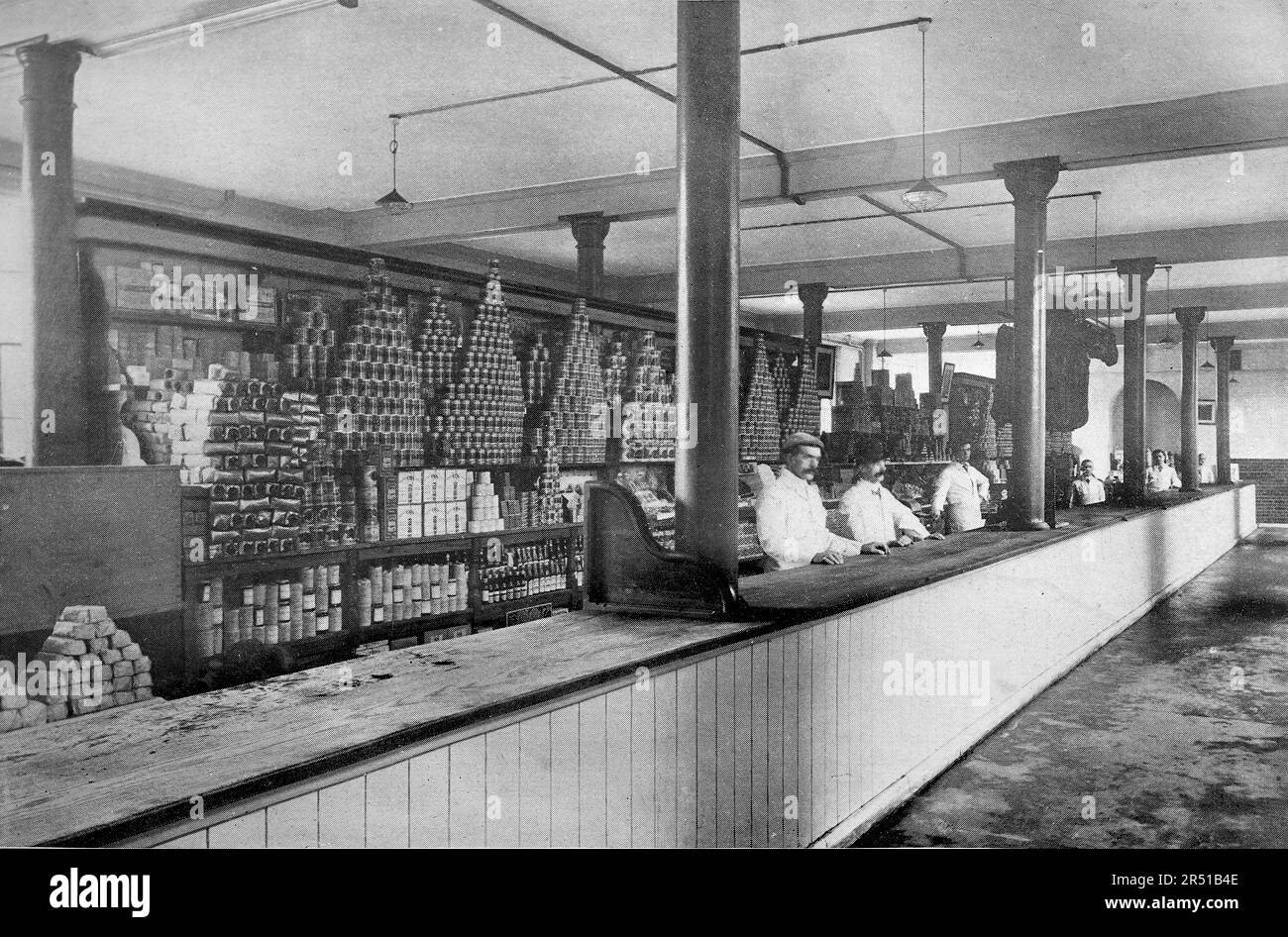 RN Caserma Chatham, c1904. La Cantina secca: Una lunga area di servizio, come un bar, con scaffali di prodotti secchi dietro e personale di servizio. La costruzione della caserma iniziò nel 1897 e fu completata nel 1902. Le caserme erano note anche come HMS Pembroke e sono state utilizzate fino al 1961 per la flotta di riserva. In questo periodo la caserma è stata integrata nel cantiere navale e nella base navale fino alla chiusura di entrambi e alla disattivazione di HMS Pembroke nel 1984. Foto Stock