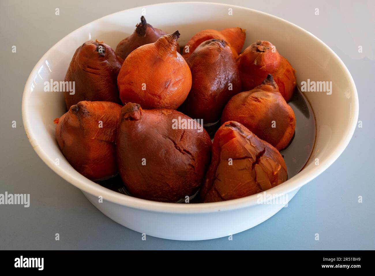 Cotogne arrostite al forno in sciroppo di vino rosso speziato alla cannella secondo una ricetta di Maggie Beer Foto Stock