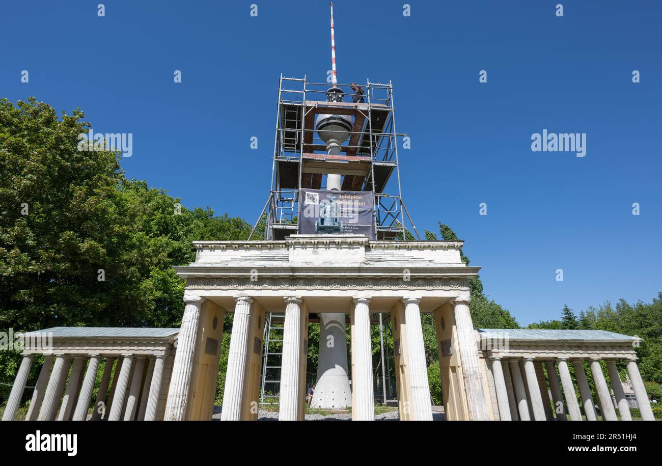 31 maggio 2023, Sassonia, Lichtenstein: Dietro la porta di Brandeburgo, André Döhn lavora sul modello della torre della televisione di Berlino a Minibelt a Lichtenstein. Il modello alto 14,60 metri su una scala di 1:25 fu uno dei primi modelli del Miniwelt nel 1999. sono passati 13 anni dall'ultimo restauro. Vento e meteo, sole, pioggia, neve e gelo hanno preso il loro pedaggio sulla struttura e ora richiedono un'altra revisione generale. Durante il processo, le parti allentate sono già state rimosse. Attualmente, la sfera e l'albero sono in fase di restauro nel mini mondo, più di 100 punti di riferimento nazionali e internazionali o Foto Stock