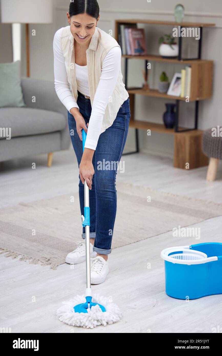 Donna, spazzare il pavimento del soggiorno e pulire con igiene e manutenzione, pulizia e sorriso mentre si lavora. Disinfezione, batteri puliti e femmina Foto Stock