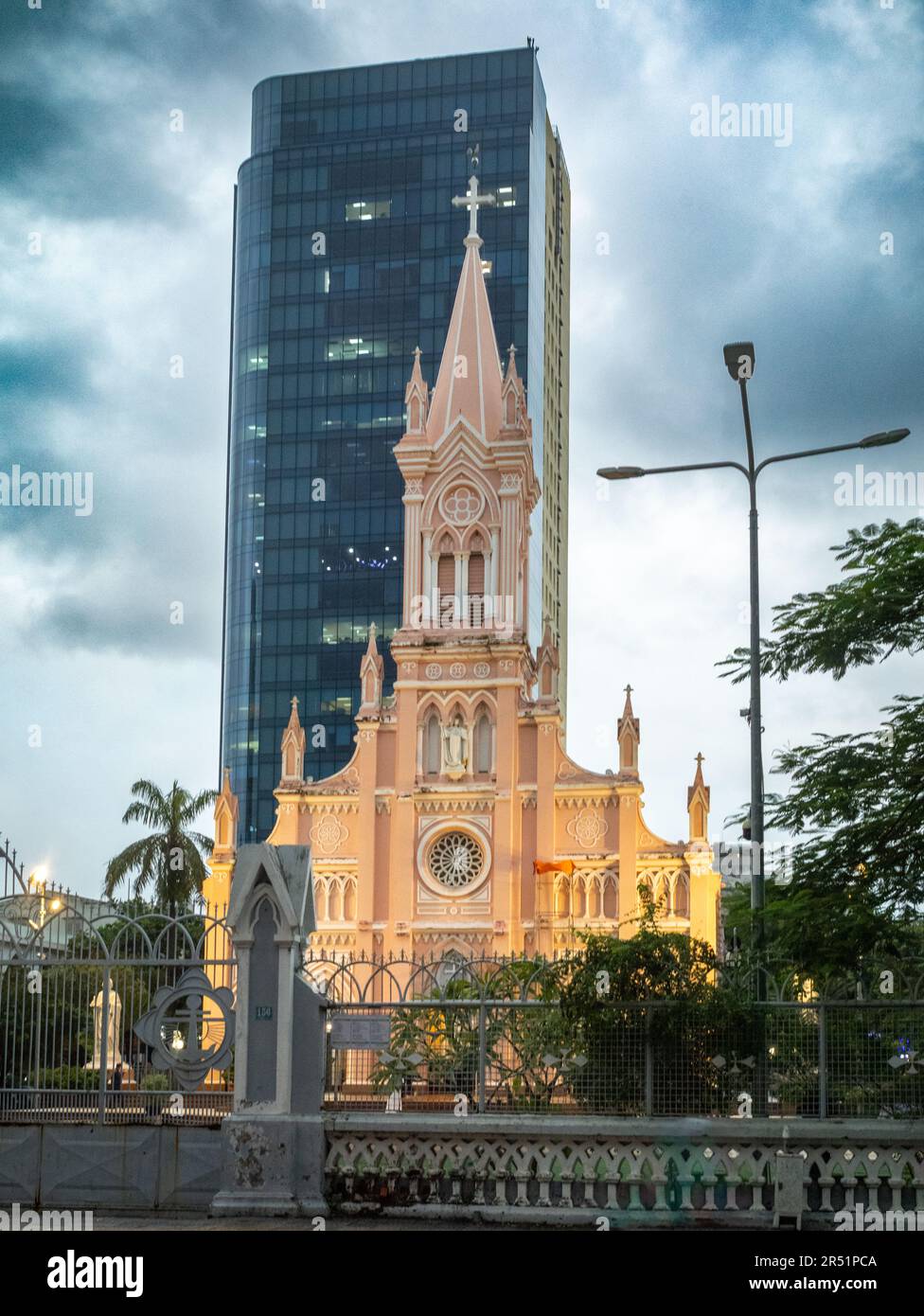 La Cattedrale di Danang in Vietnam è annidata da un alto e moderno edificio di uffici. Foto Stock